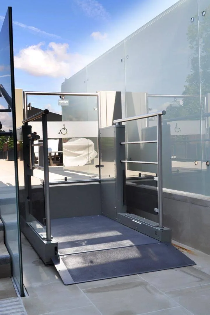 Outdoor platform lift with access ramp at the bottom of steps